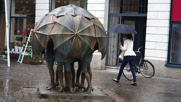 Люди под зонтом во время дождя, памятник непогоде - Sputnik Латвия