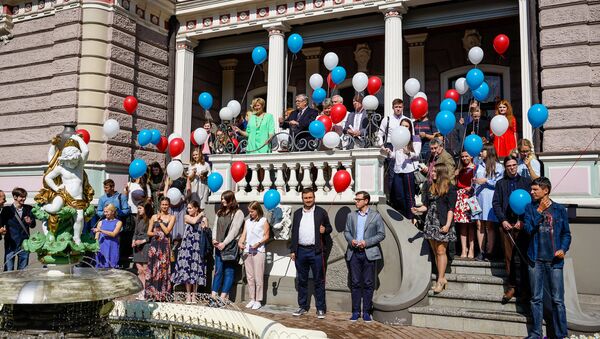Будущие студенты вместе с послом и членами комиссии вышли на лестницу посольства и по традиции выпустили в небо воздушные шарики в цветах российского флага - Sputnik Латвия