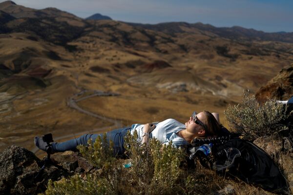 Девушка наблюдает за солнечным затмением на живописных холмах близ Митчелла, штат Орегон, США - Sputnik Латвия