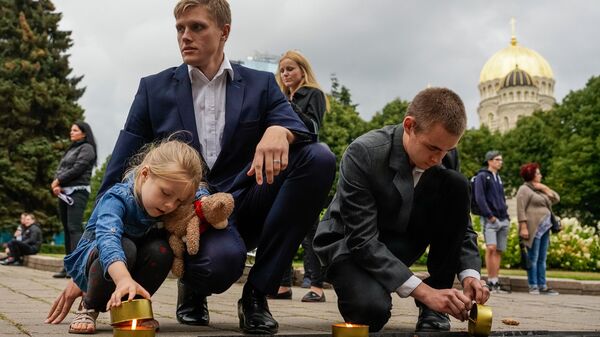 Депутат Сейма от партии Все для Латвии — Отчизне и свободе/ДННЛ Янис Домбрава с дочкой на акции памяти начала третьей Атмоды - Sputnik Латвия