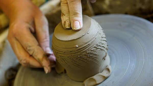 Под умелыми руками на гончарном круге рождается будущий горшочек - Sputnik Латвия