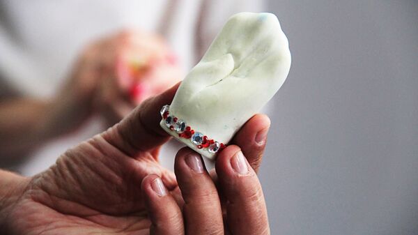 Модель клыка, который профессор считает модулем остальных жевательных зубов и слепком кисти человека - Sputnik Латвия