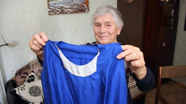 Валентина Чистякова держит в руках платье, в котором она выступала в 1957 году - Sputnik Латвия