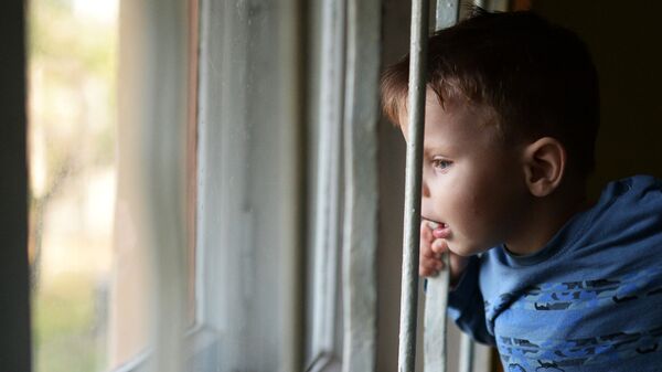 Воспитанник детского дома смотрит в окно - Sputnik Latvija