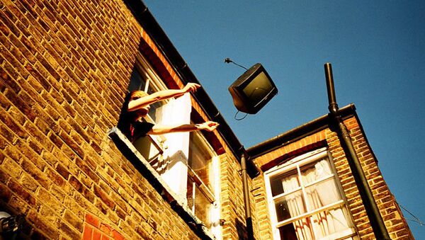 Мужчина выбрасывает ТВ из окна дома - Sputnik Латвия