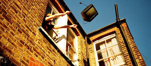 Мужчина выбрасывает ТВ из окна дома - Sputnik Латвия