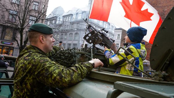 Канадский военный показывает мальчику пулемет М240 в Риге - Sputnik Латвия