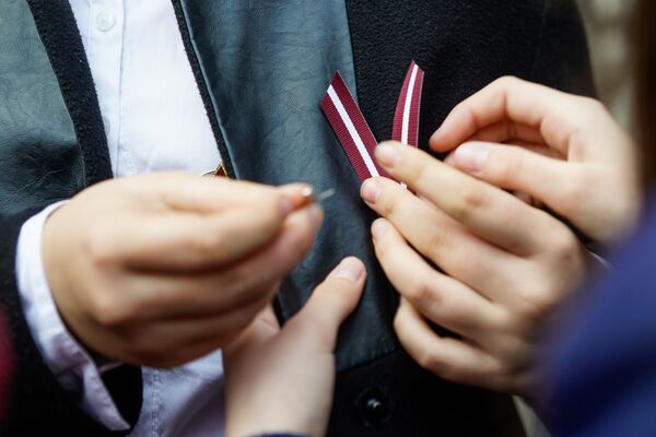 Дети прикалывают ленточку в цветах латвийского флага - Sputnik Латвия