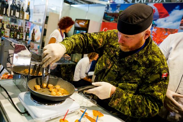 Канадский военный из сводного батальона НАТО в Латвии готовит гребешки Канадский военный из сводного батальона НАТО в Латвии готовит гребешки - Sputnik Латвия