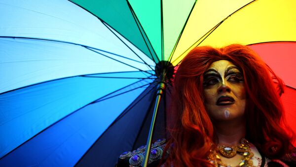 Член ЛГБТ-сообщества с зонтиком во время парада - Sputnik Latvija