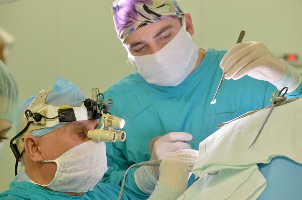 Академик Арнольд Смеянович и врач-нейрохирург Антон Родич проводят операцию по удалению опухоли головного мозга - Sputnik Латвия