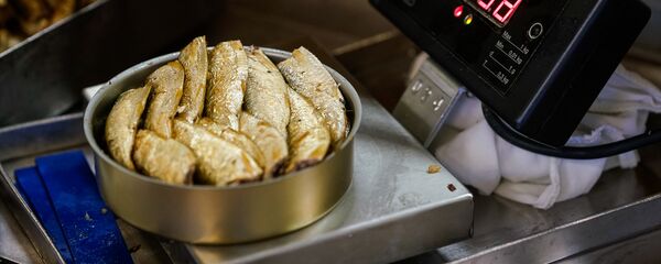 Готовая банка со шпротами взвешивается и отправляется дальше - Sputnik Latvija