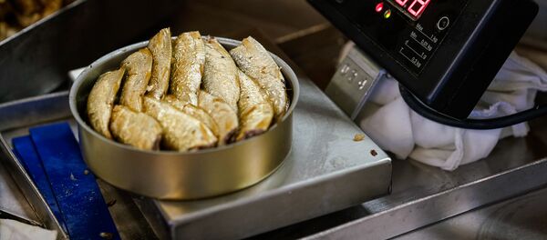 Готовая банка со шпротами взвешивается и отправляется дальше - Sputnik Latvija