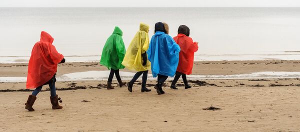 Девушки в дождевиках на пляже Юрмалы Девушки в дождевиках на пляже Юрмалы - Sputnik Latvija