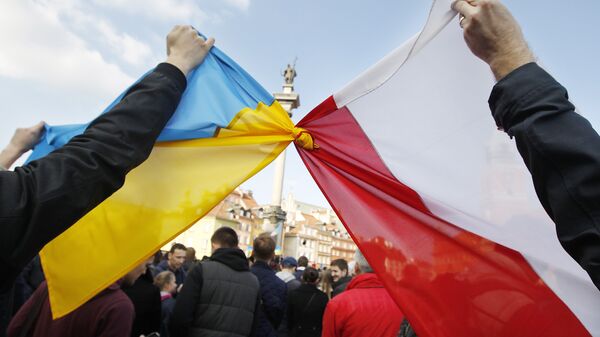 Люди держат связанные флаги Польши и Украины в Варшаве - Sputnik Латвия