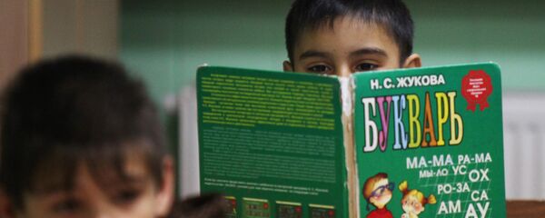 Ученик начальной школы с букварем Ученик начальной школы с букварем - Sputnik Латвия