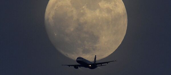 Самолет на фоне полной луны в небе над Лондоном, Великобритания - Sputnik Латвия