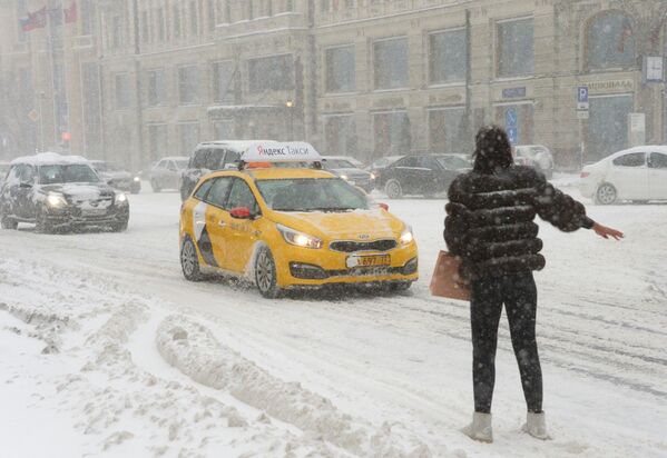 Meitene cenšas noķert taksi Tveras ielā sniegputenī - Sputnik Latvija
