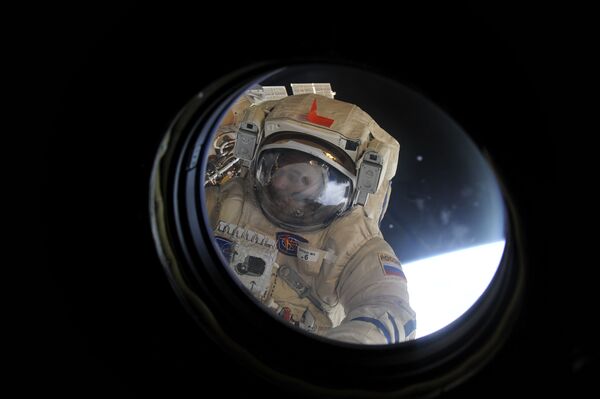 Космонавт Роскосмоса Михаил Корниенко выполняет задачу по очистке иллюминатора МКС - Sputnik Латвия