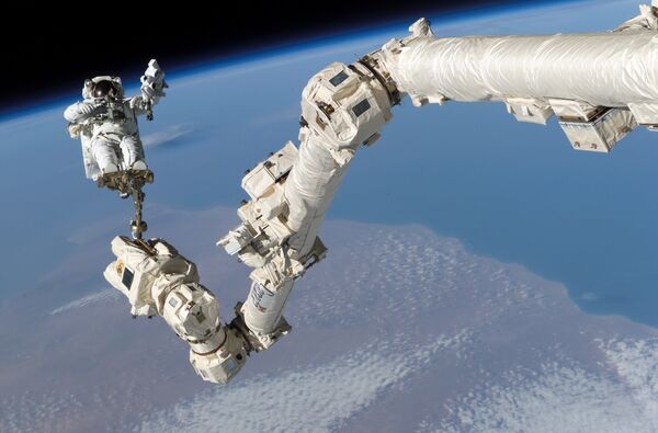 Астронавт Стивен Керн Робинсон в открытом космосе рядом с МКС - Sputnik Латвия