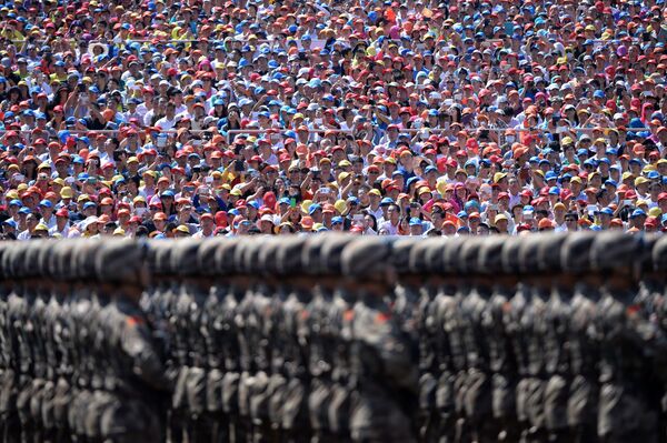 Зрители наблюдают за маршем китайских солдат во  время военного парада на площади Тяньаньмэнь в Пекине - Sputnik Латвия
