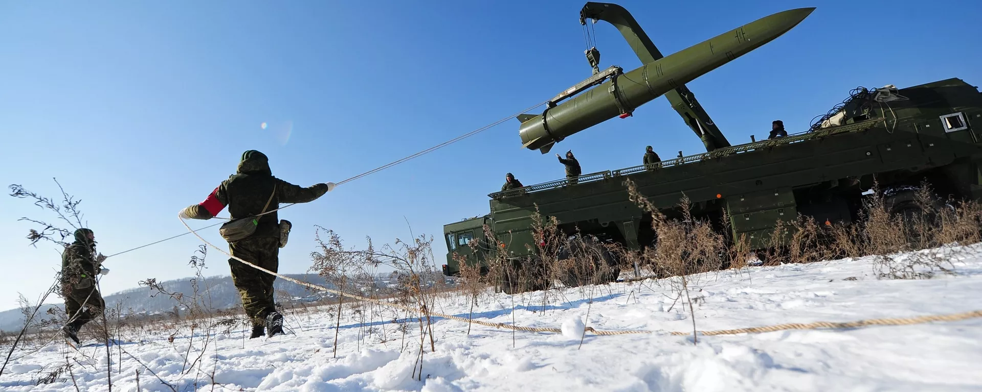 Военнослужащие ВС РФ контролируют загрузку ракеты транспортно-заряжающий машиной на самоходную пусковую установку оперативно-тактического ракетного комплекса Искандер-М - Sputnik Latvija, 1920, 11.03.2021