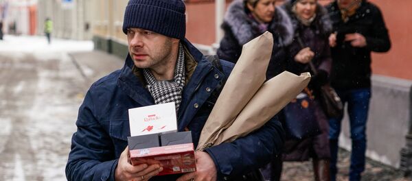 Мужчина спешит поздравить коллег по работе с праздником 8 марта Мужчина спешит поздравить коллег по работе с праздником 8 марта - Sputnik Латвия