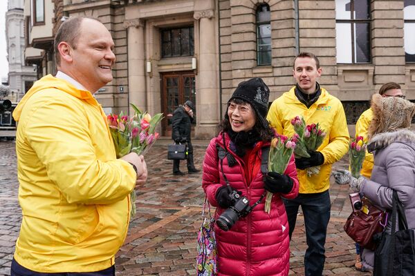 Туристы из Японии счастливы получить цветы в Международный женский день - Sputnik Латвия