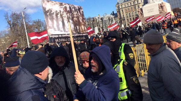 Иностранец с антинацистским плакатом, задержанный на шествии легионеров СС в Риге Иностранец с антинацистским плакатом, задержанный на шествии легионеров СС в Риге - Sputnik Латвия