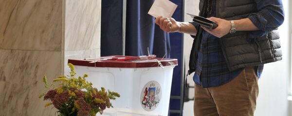 Житель города Риги на одном из избирательных участков во время голосования на парламентских выборах в Латвии. - Sputnik Латвия