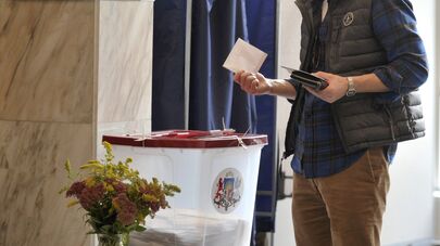 Житель города Риги на одном из избирательных участков во время голосования на парламентских выборах в Латвии.