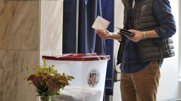 Житель города Риги на одном из избирательных участков во время голосования на парламентских выборах в Латвии. - Sputnik Латвия