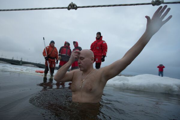 Верующий в крещенской купели у Петропавловской крепости в Санкт-Петербурге Верующий в крещенской купели у Петропавловской крепости в Санкт-Петербурге - Sputnik Латвия