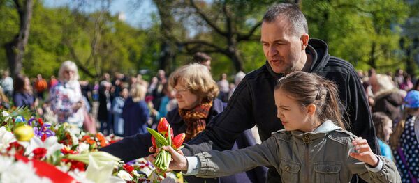 Rīgas iedzīvotāji aizpilda ar ziediem Latvijas kontūru Brīvības pieminekļa pakājē Rīgas iedzīvotāji aizpilda ar ziediem Latvijas kontūru Brīvības pieminekļa pakājē - Sputnik Latvija