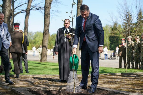 Раймондс Вейонис сажает дерево 8 мая на Братском кладбище в Риге Раймондс Вейонис сажает дерево 8 мая на Братском кладбище в Риге - Sputnik Латвия