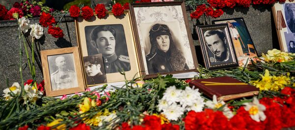 Портреты победителей у подножия памятника Освободителям 9 мая в Риге - Sputnik Латвия