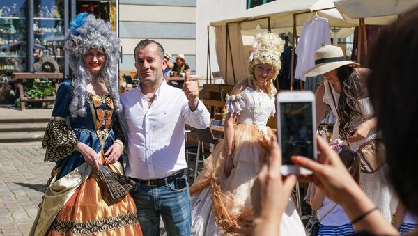 Туристы фотографируются с участниками фестиваля Майский граф - 2018 в Риге - Sputnik Latvija