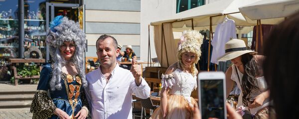 Туристы фотографируются с участниками фестиваля Майский граф - 2018 в Риге Туристы фотографируются с участниками фестиваля Майский граф - 2018 в Риге - Sputnik Latvija