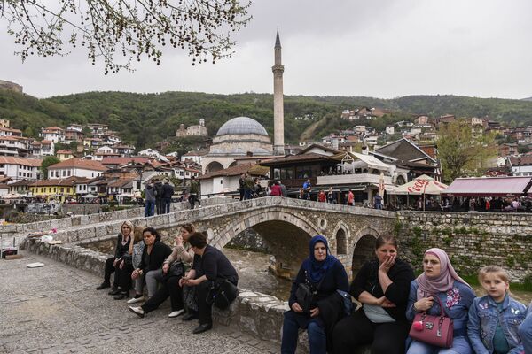 Ново и интересно - Lonely Planet советует посетить Косово. На фото - люди сидят рядом с каменным мостом с видом на город Призрен - Sputnik Латвия