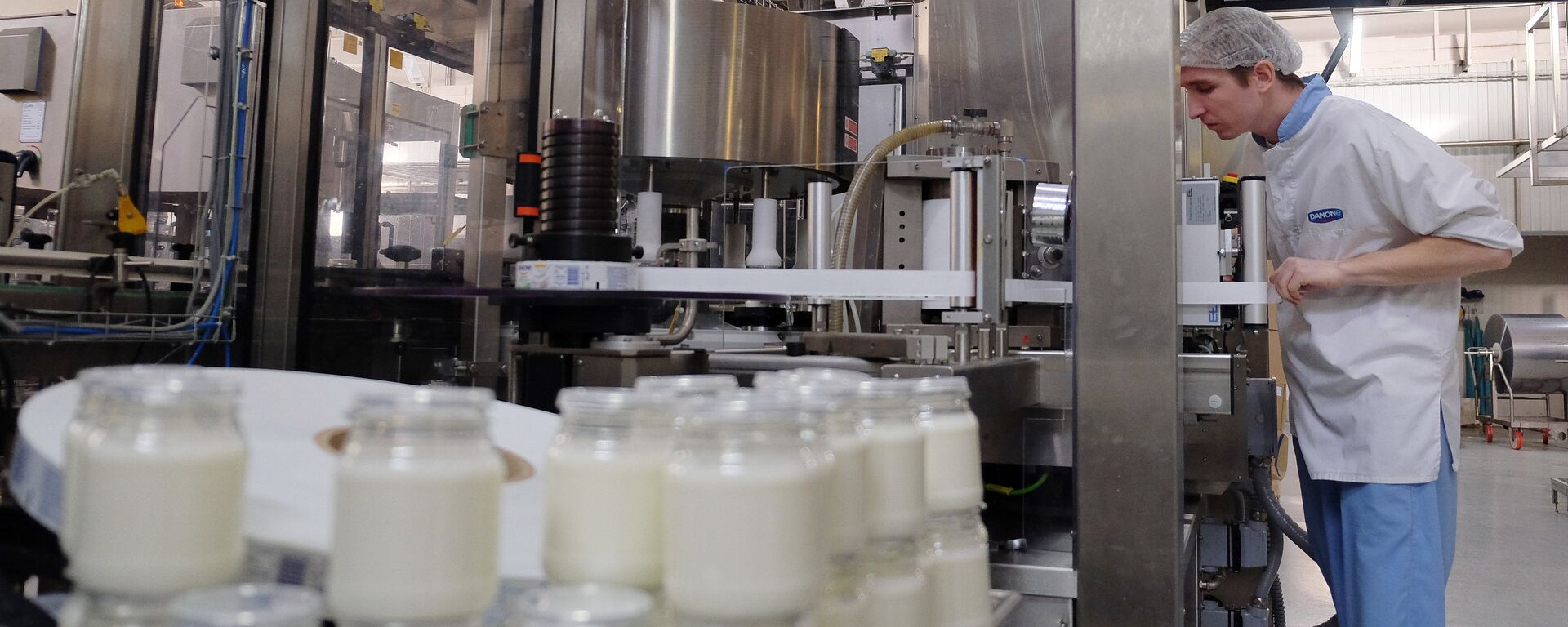 Сотрудник на производственной линии по упаковке молочной продукции - Sputnik Латвия, 1920, 20.02.2026