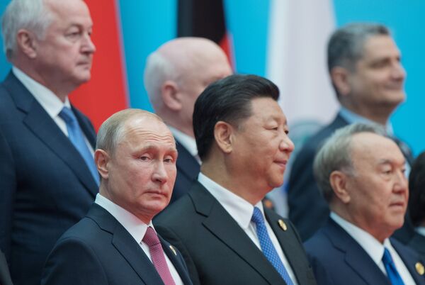 Президент РФ Владимир Путин на церемонии фотографирования глав государств - членов ШОС, наблюдателей в ШОС и руководителей международных организаций. Справа налево - президент Казахстана Нурсултан Назарбаев и председатель КНР Си Цзиньпин, 10 июня 2018 Президент РФ Владимир Путин на церемонии фотографирования глав государств - членов ШОС, наблюдателей в ШОС и руководителей международных организаций. Справа налево - президент Казахстана Нурсултан Назарбаев и председатель КНР Си Цзиньпин, 10 июня 2018 - Sputnik Латвия