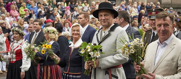 Президент Латвии Раймондс Вейонис с супругой, одетые в народные костюмы, во время шествия участников Праздника песни и танца - Sputnik Латвия