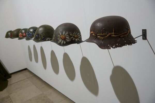 Литовская художница Северия Инчираускайте-Крауневичиене вышивает крестиком цветы на армейских касках. Ее инсталляция Убить во имя мира - гимн пацифизму Литовская художница Северия Инчираускайте-Крауневичиене вышивает крестиком цветы на армейских касках. Ее инсталляция Убить во имя мира - гимн пацифизму - Sputnik Латвия