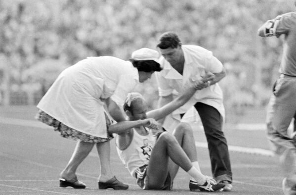 Врачи оказывают помощь легкоатлету, получившему травму во время соревнований. XXII летние Олимпийские игры в Москве, 1980 год - Sputnik Латвия
