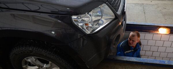 Сотрудник станции ТО СТД-Новосибирск проводит технический осмотр автомобиля. Сотрудник станции ТО СТД-Новосибирск проводит технический осмотр автомобиля. - Sputnik Latvija