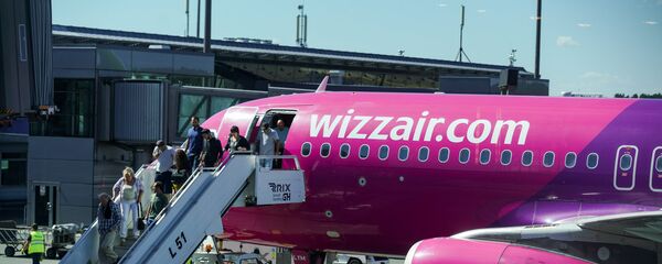 Пассажиры выходят из самолета Wizz Air в аэропорту Рига Пассажиры выходят из самолета Wizz Air в аэропорту Рига - Sputnik Латвия