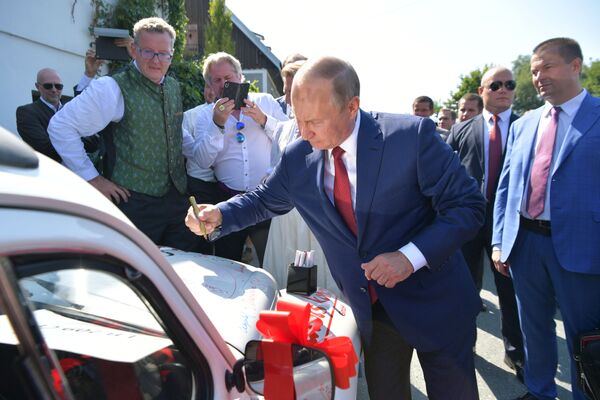 Президент России Владимир Путин пишет пожелания на автомобиле на свадьбе министра иностранных дел Австрии Карин Кнайсль и финансиста Вольфганга Майлингера - Sputnik Латвия