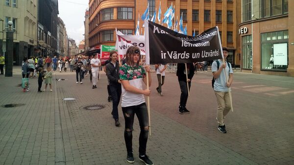 Митингующие несут транспарант с надписью: У каждого антигосударственного решения есть имя и фамилия - Sputnik Латвия