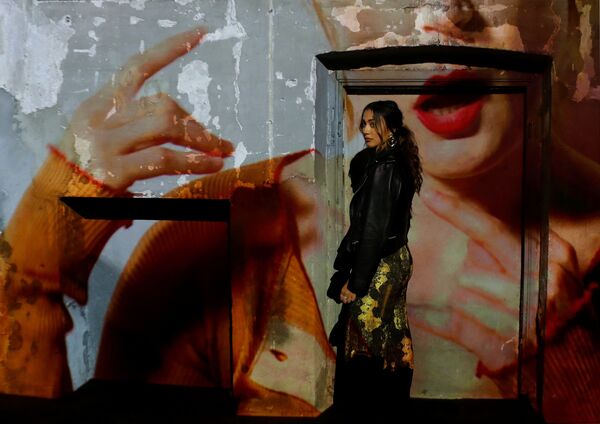 Гостья на фоне видеопроекции во время показа мод на Неделе моды в Милане. - Sputnik Латвия