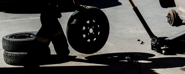 Работник меняет колесо в шиномонтажной мастерской Работник меняет колесо в шиномонтажной мастерской - Sputnik Latvija